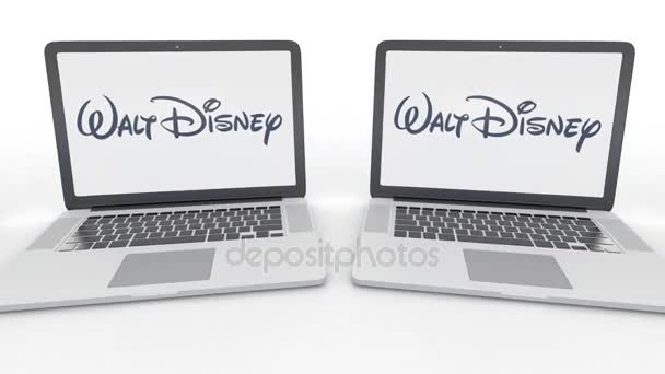 Ноутбуки с логотипом Walt Disney Pictures на экране. Концептуальная редакционная работа по компьютерным технологиям 4К клип, бесшовный цикл — стоковое видео