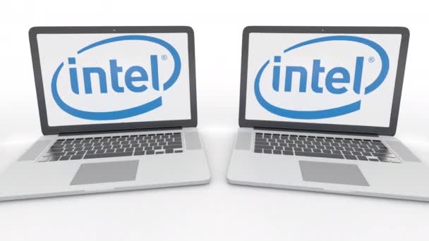 Ноутбуки с логотипом Intel Corporation на экране. Концептуальная редакционная работа по компьютерным технологиям 4К клип, бесшовный цикл — стоковое видео