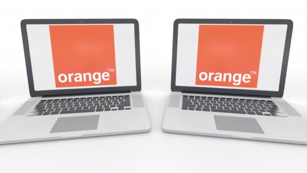 Notebooks com logotipo da Orange S.A. na tela. Tecnologia de computador editorial conceitual clipe 4K, loop sem costura — Vídeo de Stock