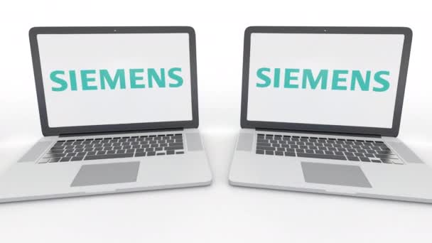 Siemens logo üstünde belgili tanımlık perde ile dizüstü bilgisayar. Bilgisayar teknolojisi kavramsal editoryal 4k klip, sorunsuz döngü — Stok video