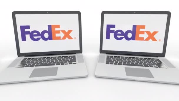 Fedex logo üstünde belgili tanımlık perde ile dizüstü bilgisayar. Bilgisayar teknolojisi kavramsal editoryal 4k klip, sorunsuz döngü — Stok video