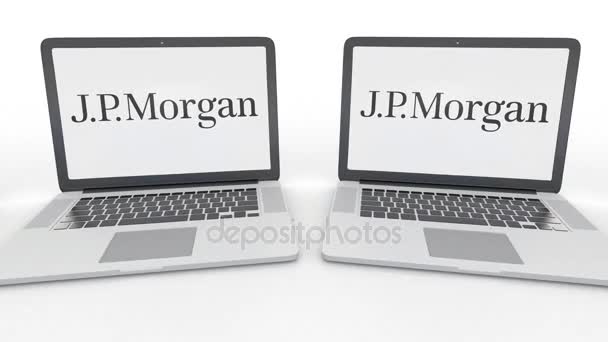 J.P. Morgan logo üstünde belgili tanımlık perde ile dizüstü bilgisayar. Bilgisayar teknolojisi kavramsal editoryal 4k klip, sorunsuz döngü — Stok video