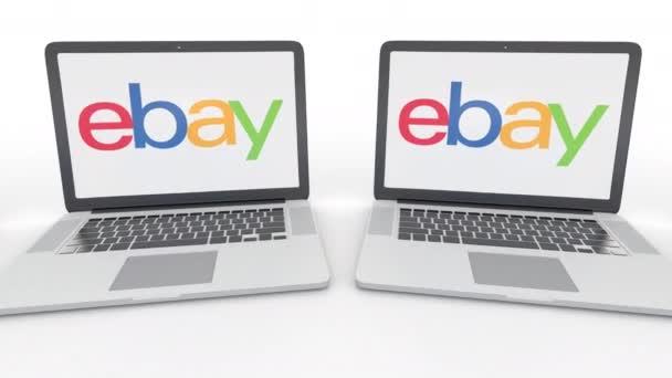 Ноутбуки с логотипом eBay Inc. на экране. Концептуальная редакционная работа по компьютерным технологиям 4К клип, бесшовный цикл — стоковое видео