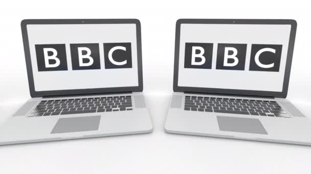 Cuadernos con el logotipo de la BBC de British Broadcasting Corporation en la pantalla. Tecnología informática editorial conceptual clip 4K, bucle sin costura — Vídeo de stock