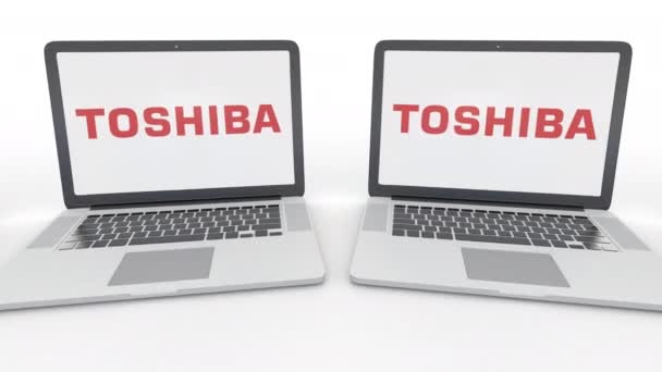 Notebook Toshiba Corporation logo üstünde belgili tanımlık perde ile. Bilgisayar teknolojisi kavramsal editoryal 4k klip, sorunsuz döngü — Stok video