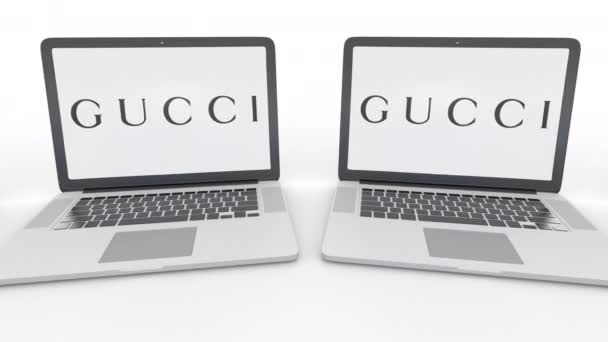 Notebooks com logotipo Gucci na tela. Tecnologia de computador editorial conceitual clipe 4K, loop sem costura — Vídeo de Stock