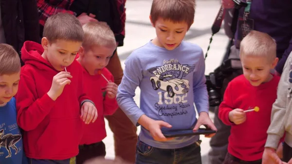 GARANTIA, POLÓNIA - MARÇO, 4, 2017. Meninos que operam entusiasticamente pequenos robôs usando o computador tablet — Fotografia de Stock