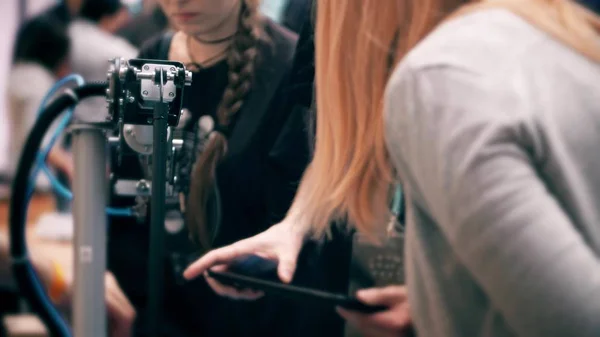 Engineer demonstrates robotic arm control to female visitors — Stock Photo, Image