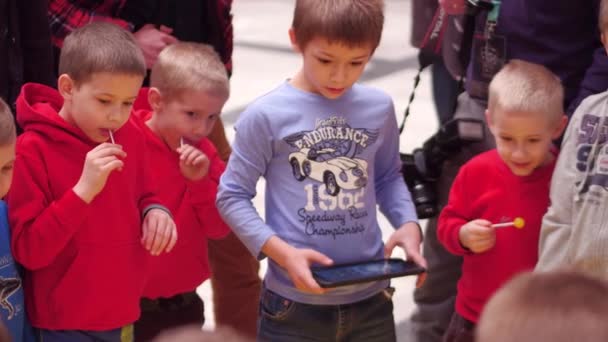 바르샤바, 폴란드-3 월 4, 2017. 열정적으로 태블릿 컴퓨터를 사용 하 여 작은 로봇을 운영 하는 작은 소년. 4 k 비디오 — 비디오