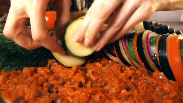 Mettere le verdure affettate in una padella di vetro. Cucina amatoriale di ratatouille a casa. Note di alimentazione e concetti di mix. Video 4K — Video Stock