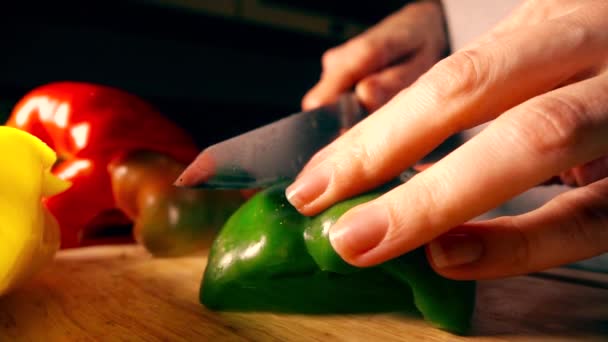 Молодая женщина режет сочный зеленый сладкий перец. Концепция здорового питания. 4K замедленное видео — стоковое видео