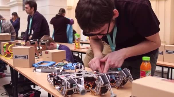 Warszawa, Polen - mars 4, 2017. Ung töntig man reparera Diy hexapod robot. 4k-video — Stockvideo