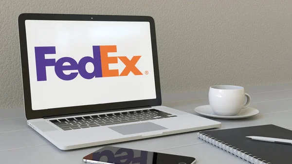 Laptop, a képernyőn a Fedex logóval. Modern munkahelyi fogalmi szerkesztői 3d-leképezés — Stock Fotó