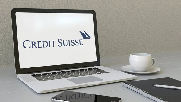 Laptop med Credit Suisse Group-logotypen på skärmen. Moderna arbetsplatser konceptuella redaktionella 3d-rendering Stockfoto