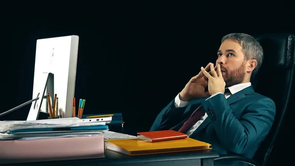 Pennen bebaarde zakenman swingende op zijn bureaustoel. Zwarte achtergrond — Stockfoto