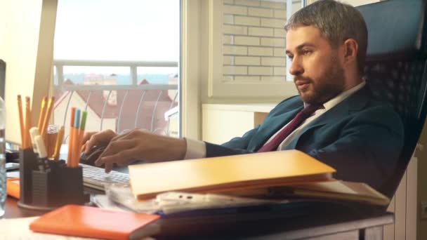 Ernstige vertrouwen zakenman op zijn computer op kantoor werkt. 4k video — Stockvideo
