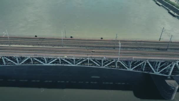 WARSAW, POLONIA - 26 DE MARZO DE 2017. plano aéreo del tren de pasajeros que se mueve en el puente ferroviario a través del río. Vídeo 4K — Vídeo de stock