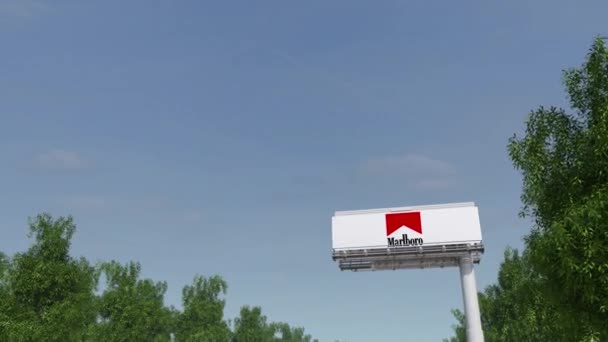 Guida verso cartellone pubblicitario con logo Marlboro. Rendering 3D editoriale clip 4K — Video Stock