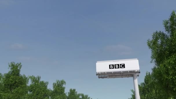 Condução para cartaz publicitário com logotipo da BBC da British Broadcasting Corporation. Editorial 3D renderização 4K clip — Vídeo de Stock