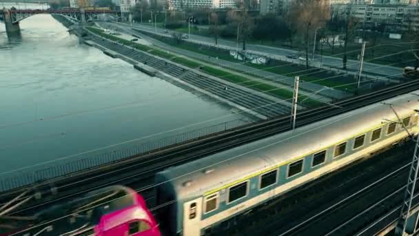 WARSAW, POLAND - March, 27, 2017. Воздушный кадр пассажирского поезда, движущегося по железнодорожному мосту через реку. 4K видео — стоковое видео