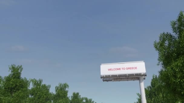 Приближаемся к большому билборду с надписью "Добро пожаловать в Грецию". 4K клип — стоковое видео