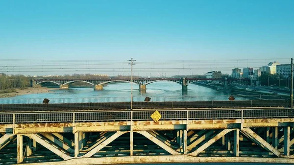 Plano aéreo de ferrocarril de acero viejo y puentes de coches distantes a través del río — Foto de Stock