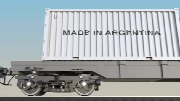 Tren de carga en movimiento y contenedores con leyenda MADE IN ARGENTINA. Transporte ferroviario. Clip 4K de bucle sin costura — Vídeos de Stock