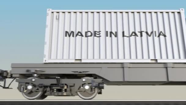 Bewegende lading trein en containers met gemaakt In Letland bijschrift. Spoorweg transport. Naadloze loops 4k clip — Stockvideo