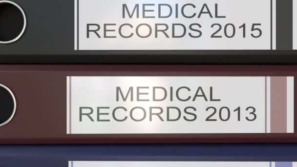Вертикальная стопка разноцветных офисных связующих с метками медицинских записей разных лет — стоковое видео