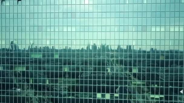 Tiro aéreo de janelas de edifício de escritório modernas que refletem paisagem urbana em um dia ensolarado. Vídeo 4K — Vídeo de Stock