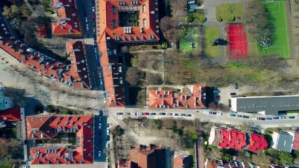 Aerial shot of european city sports grounds in residential area and sloped tiled roofs of the dwelling buildings, top view. 4K video — Stock Video