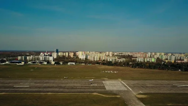 WARSAW, POLONIA - 1 DE ABRIL DE 2017. Disparo aéreo de un pequeño avión de hélice aterrizando en la pista de aterrizaje del aeropuerto de la ciudad en un día soleado —  Fotos de Stock