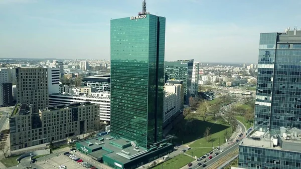 WARSAW, POLONIA - 1 DE ABRIL DE 2017. Foto aérea del moderno edificio de oficinas con leyenda de INTRACO que refleja el paisaje urbano en un día soleado — Foto de Stock