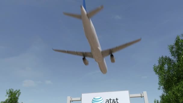 Flugzeug fliegt über Werbetafel mit amerikanischem Telefon- und Telegrafenunternehmen mit T-Logo. Editorial 3D Rendering 4k Clip — Stockvideo