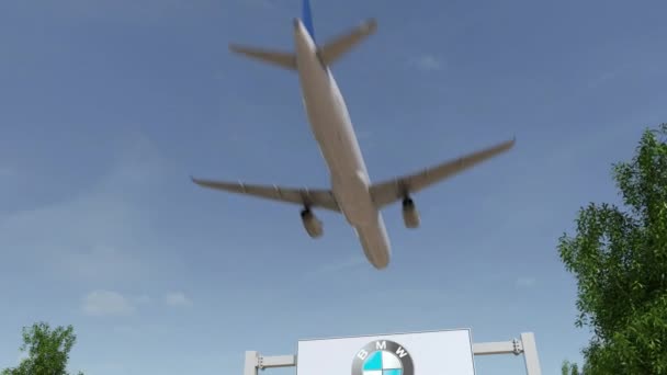 Avión volando sobre la cartelera publicitaria con el logotipo de BMW. Editorial 3D renderizado 4K clip — Vídeo de stock