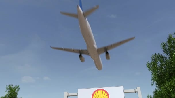 Letadlo letící nad reklamní billboard s logem Shell Oil Company. Redakční 3d vykreslování 4 k klip — Stock video