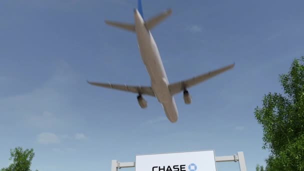 Самолет пролетает над рекламным щитом с логотипом JPMorgan Chase Bank. 3D-рендеринг 4K клипа — стоковое видео