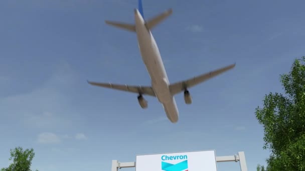Letadlo letící nad reklamní billboard s logem Chevron Corporation. Redakční 3d vykreslování 4 k klip — Stock video