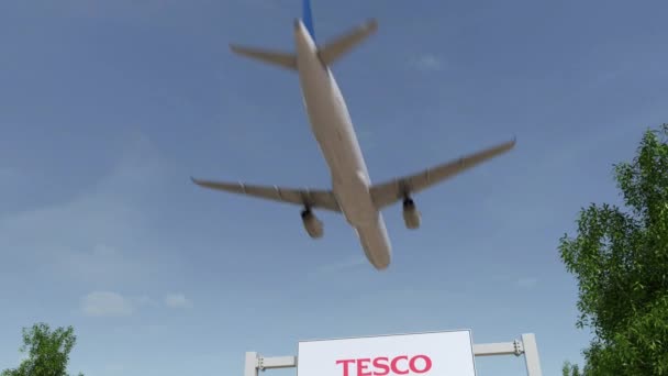 Flugzeug fliegt über Werbetafel mit tesco-Logo. Editorial 3D Rendering 4k Clip — Stockvideo
