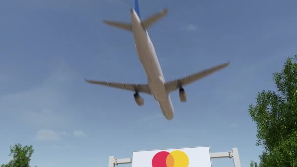 Vliegtuig vliegen over reclame bord met Mastercard-logo. Redactionele 3d rendering van 4 k-clip — Stockvideo