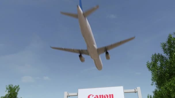 Avião voando sobre cartaz publicitário com logotipo da Canon Inc.. Editorial 3D renderização 4K clip — Vídeo de Stock