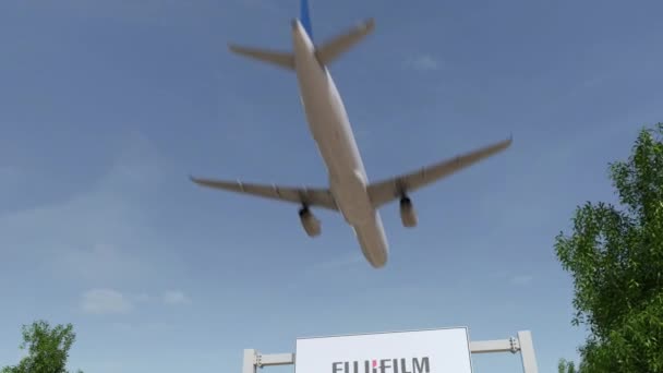 Vliegtuig vliegen over reclame bord met Fujifilm logo. Redactionele 3d rendering van 4 k-clip — Stockvideo