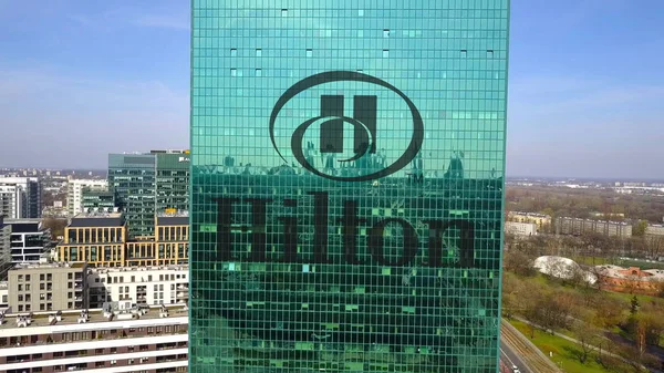 Aerial shot of office skyscraper with Hilton Hotels Resorts logo. Modern office building. Editorial 3D rendering — Stock Photo, Image