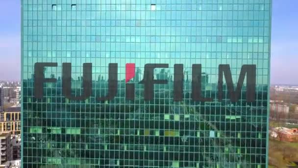 Ilmakuva pilvenpiirtäjästä Fujifilmin logolla. Nykyaikainen toimistorakennus. Toimituksellinen 3D renderöinti 4K clip — kuvapankkivideo