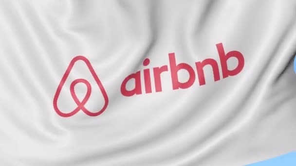 Bandera ondeando con el logotipo de Airbnb, lazo sin costuras. Clip editorial 4K — Vídeo de stock