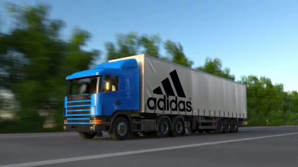 Frete semi-caminhão com inscrição Adidas e logotipo de condução ao longo da estrada da floresta, loop sem costura. Editorial 4K clip — Vídeo de Stock