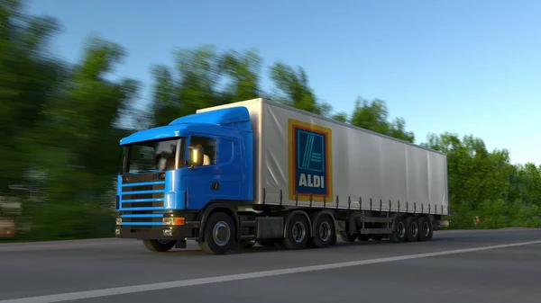 Frete semi-caminhão com logotipo Aldi dirigindo ao longo da estrada da floresta. Renderização 3D editorial — Fotografia de Stock