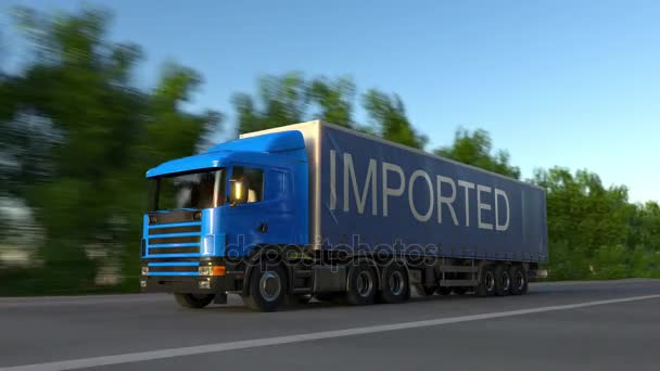 Speeding freight semi truck with IMPORTED caption on the trailer. Road cargo transportation. Seamless loop 4K clip — Stock Video