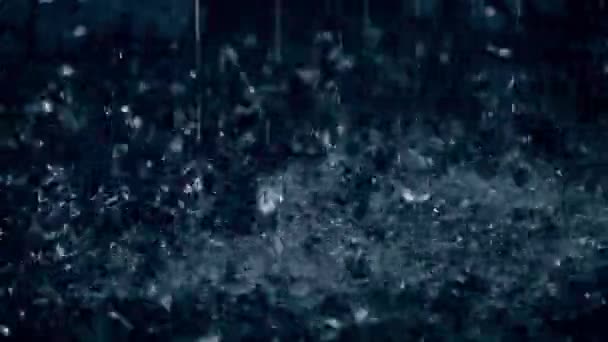 Rain drops hitting puddle in the dark close-up slow motion shot — Stock Video