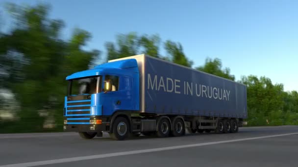 Beschleunigung Sattelschlepper mit Made in Uruguay Bildunterschrift auf dem Anhänger. Straßengüterverkehr. nahtloser 4k Clip — Stockvideo